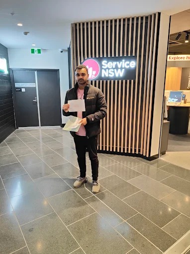 A Sydney South Driving School student outside a Service NSW centre holding test paperwork